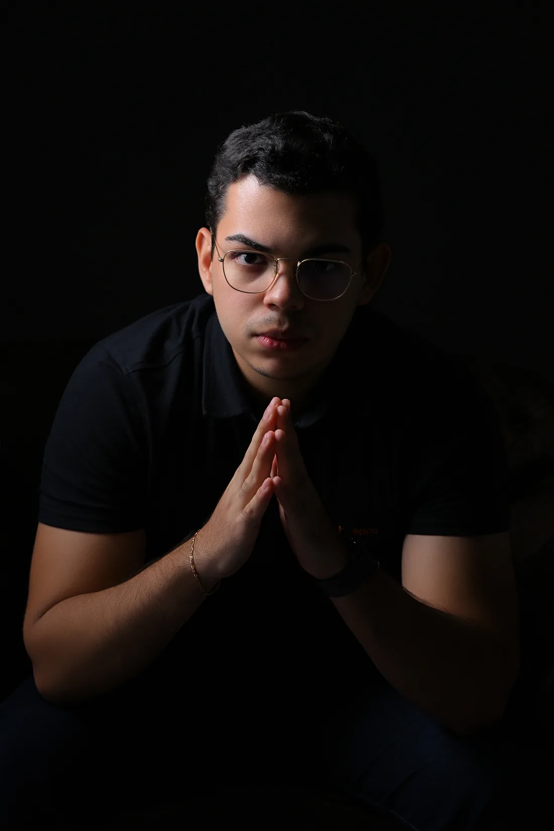 Sandro Gabryel, designer há mais de 8 anos, em retrato com as mãos unidas